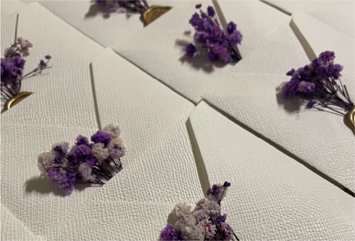 Flores em tons lilás usadas na linguagem visual da celebração.